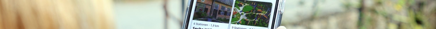 Frau schaut auf ihr Handy, dort ist die Museums-App geöffnet.