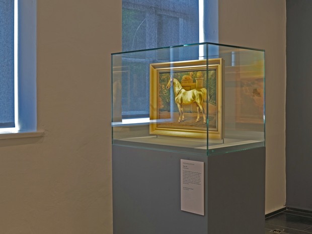 Ein Gemälde von einem Pferd in einer Glasvitrine Ein Gemälde von einem Pferd in einer Glasvitrine