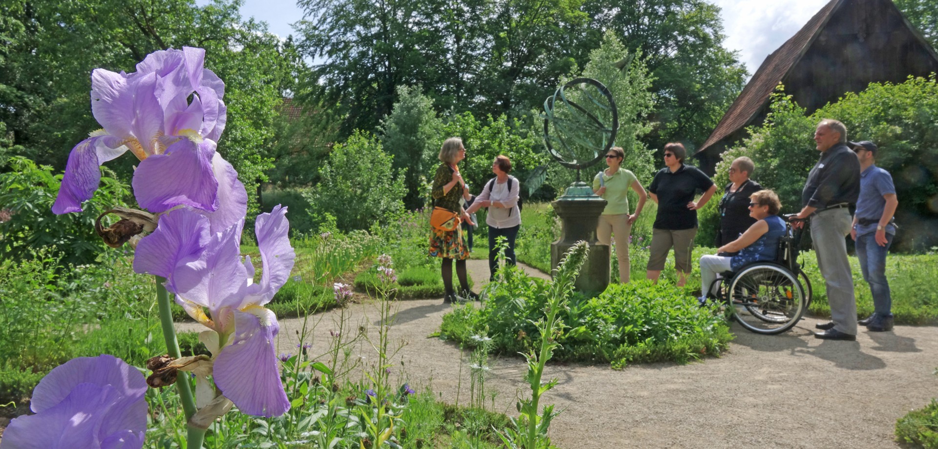 Eine Gruppe von Erwachsenen, während einer Führung im Garten.